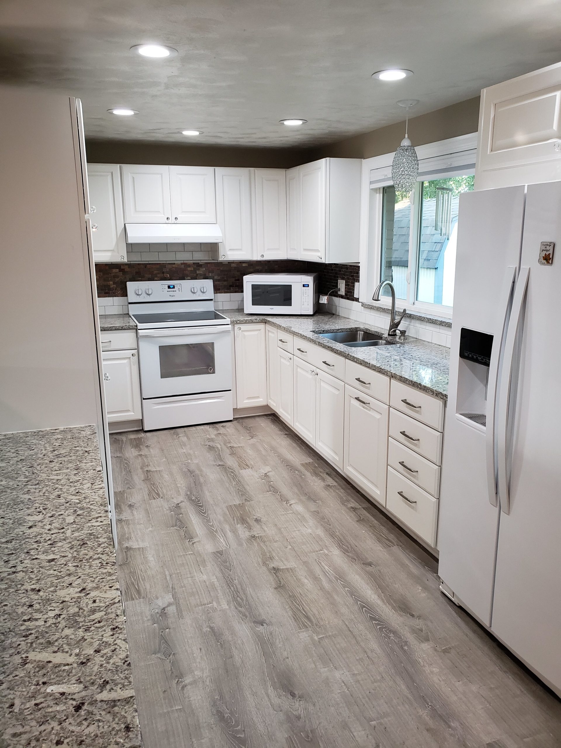 Kitchen with white cabinets and gray countertops