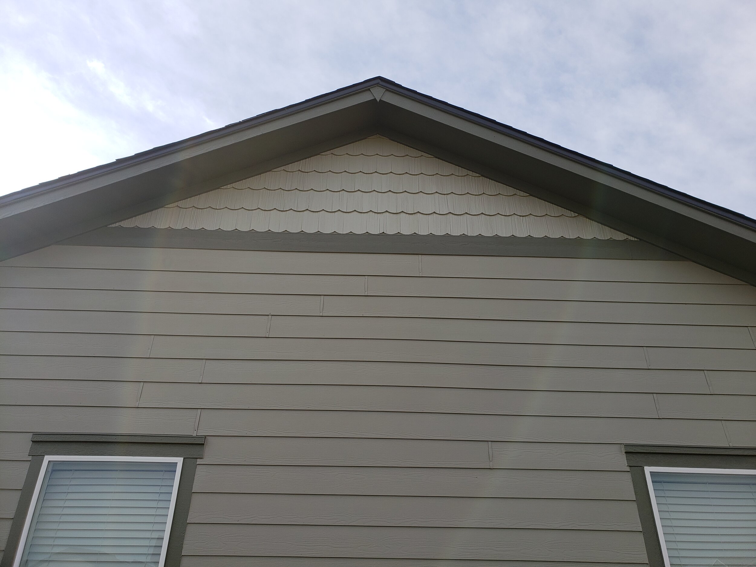 Low-angle shot of a home roofline with dark siding