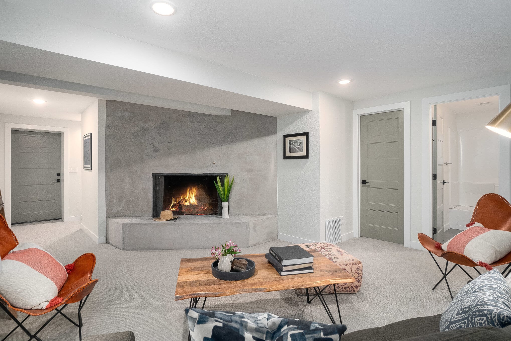 Family room with large concrete fireplace and natural wood coffee table