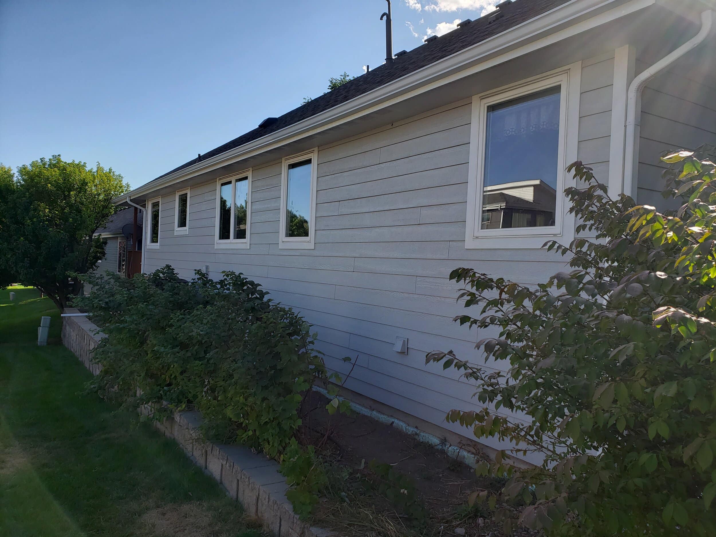 Side of a home with light gray siding and white trim