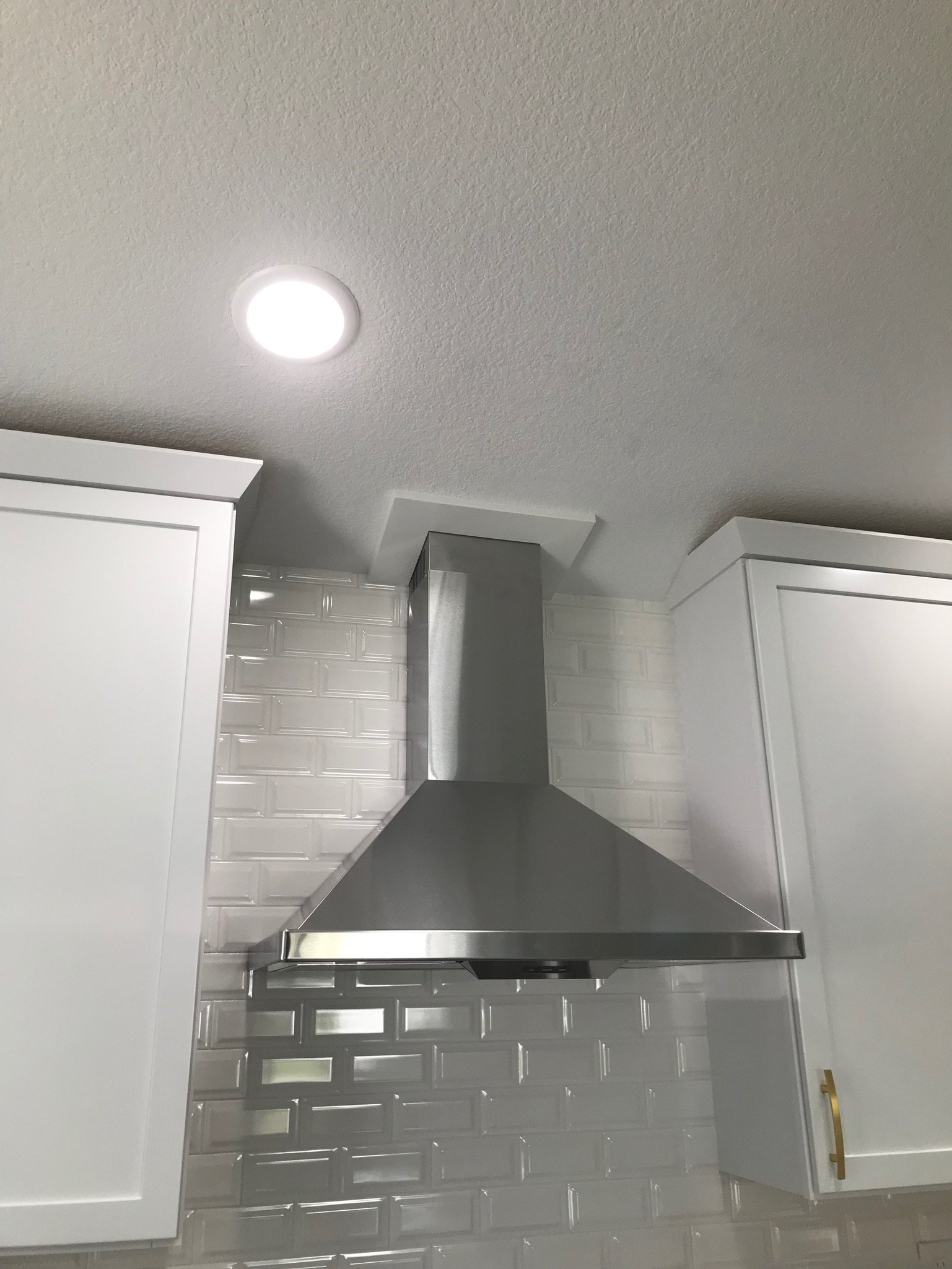 Close-up of a stainless steel range hood in kitchen