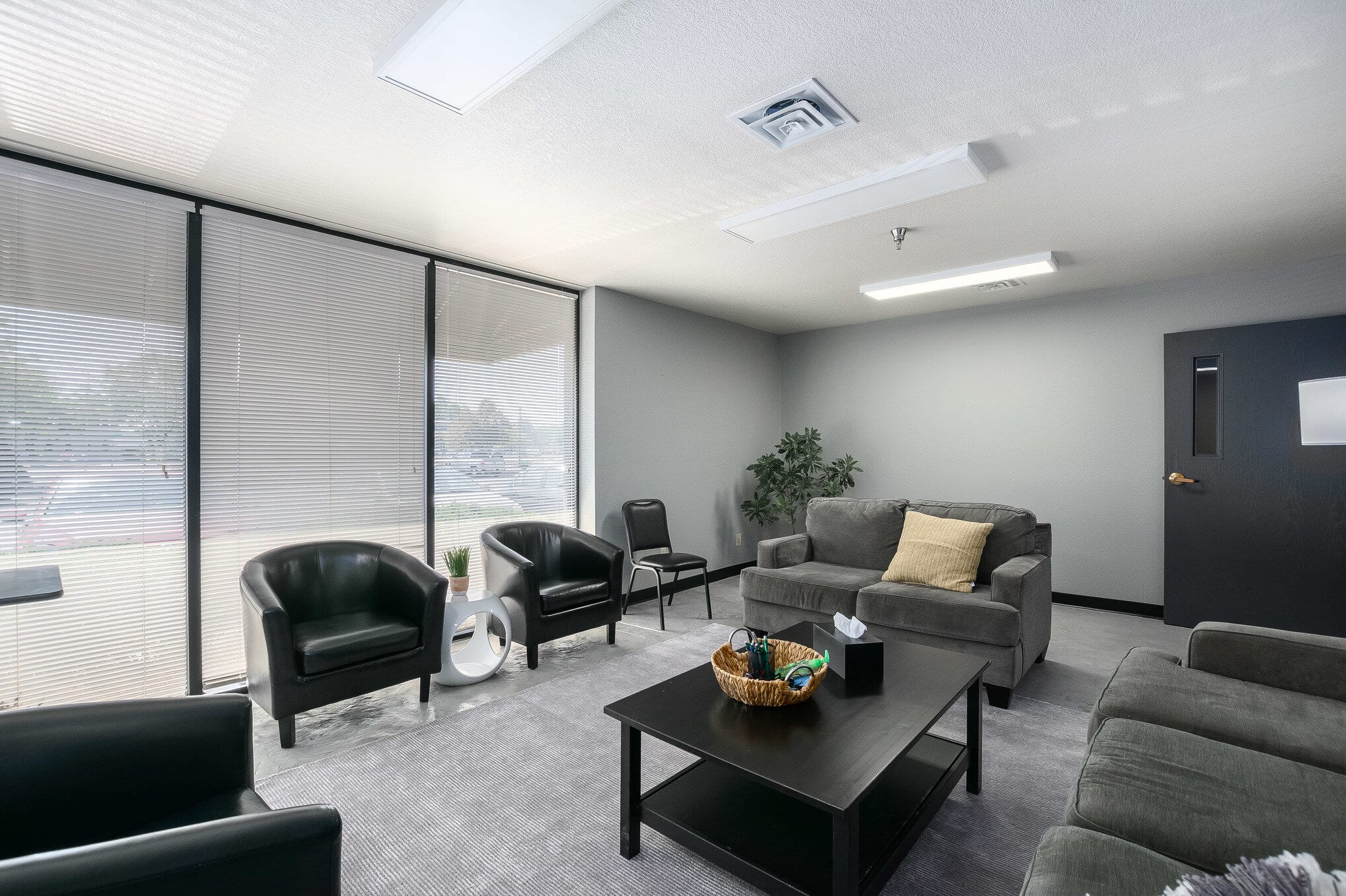 Office waiting room with black chairs and large windows