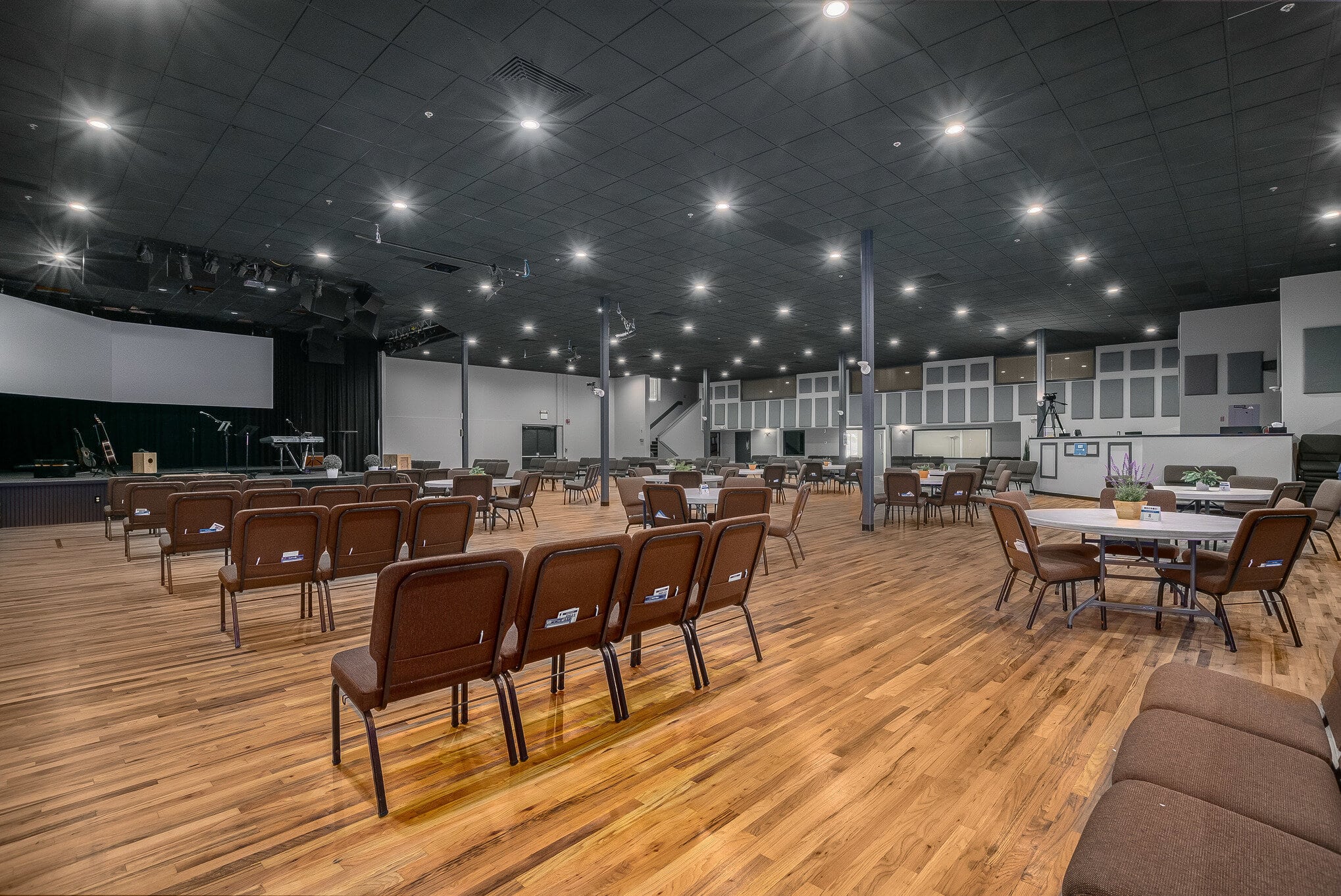 Large banquet hall with brown leather chairs and white round tables