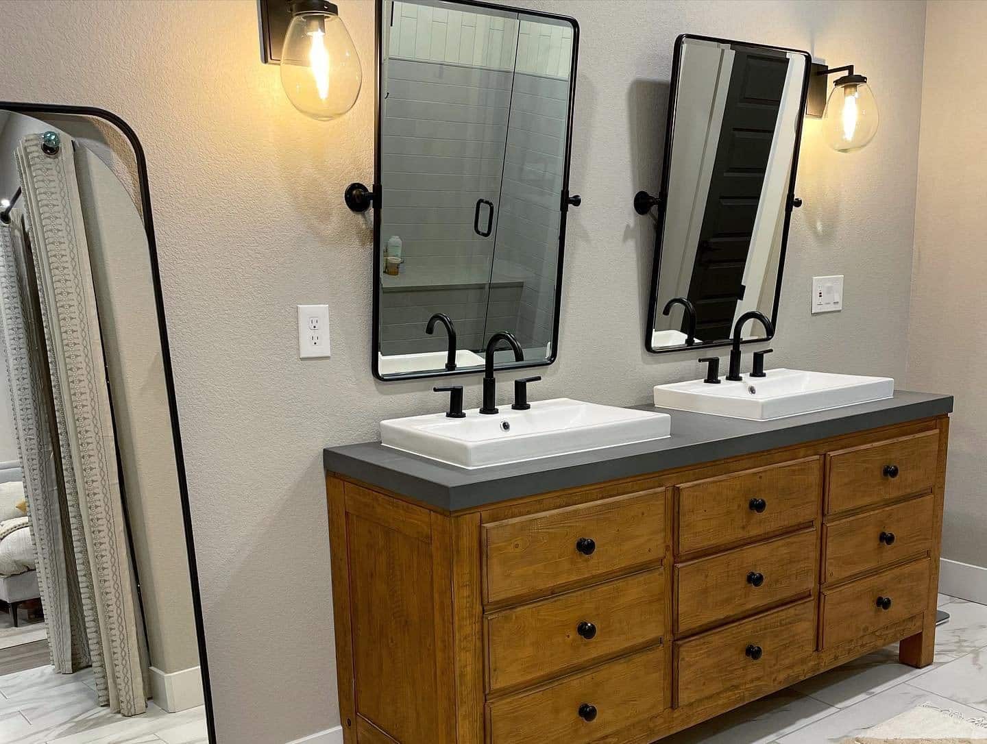Industrial style double vanity with wood cabinets and black metal trim around mirrors