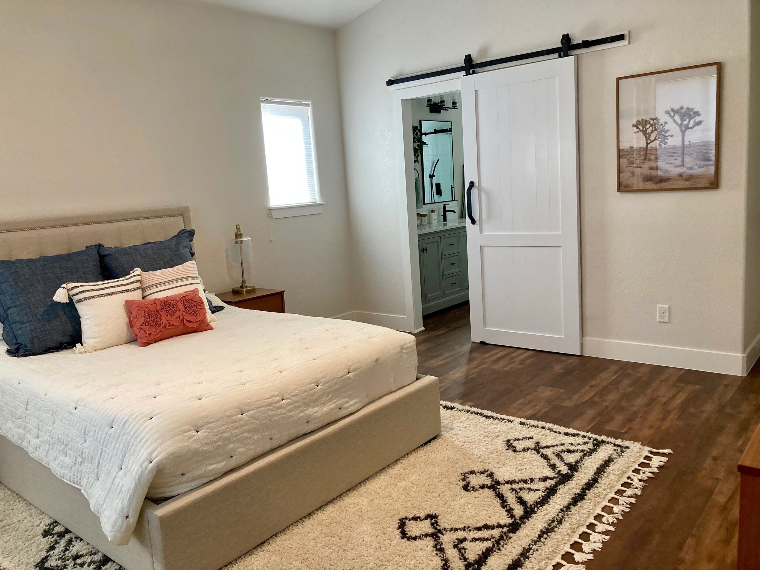 Owner's suite bedroom with sliding barn door to ensuite bathroom