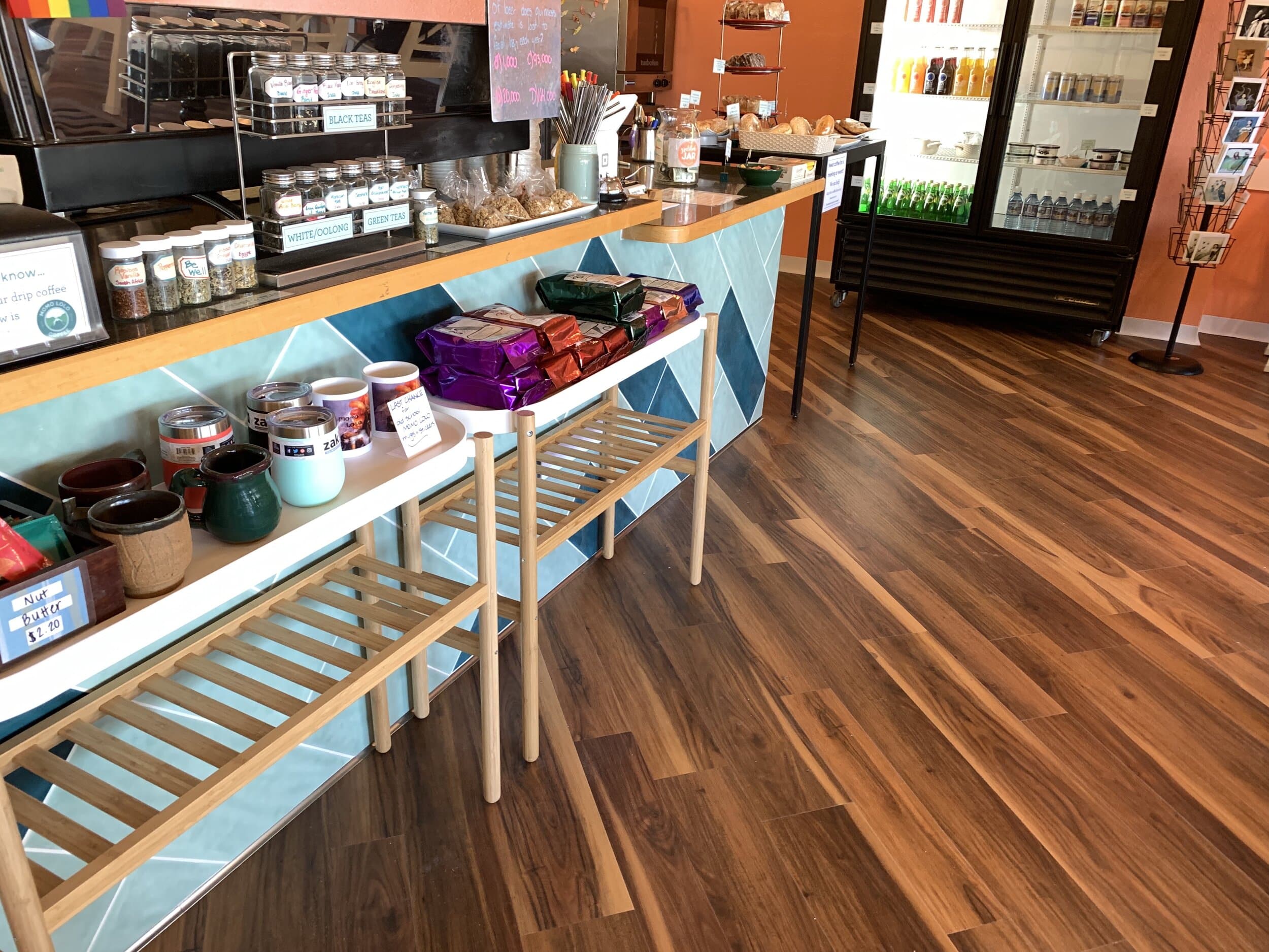 Blue tile coffee bar with hard wood floors and an orange accent wall