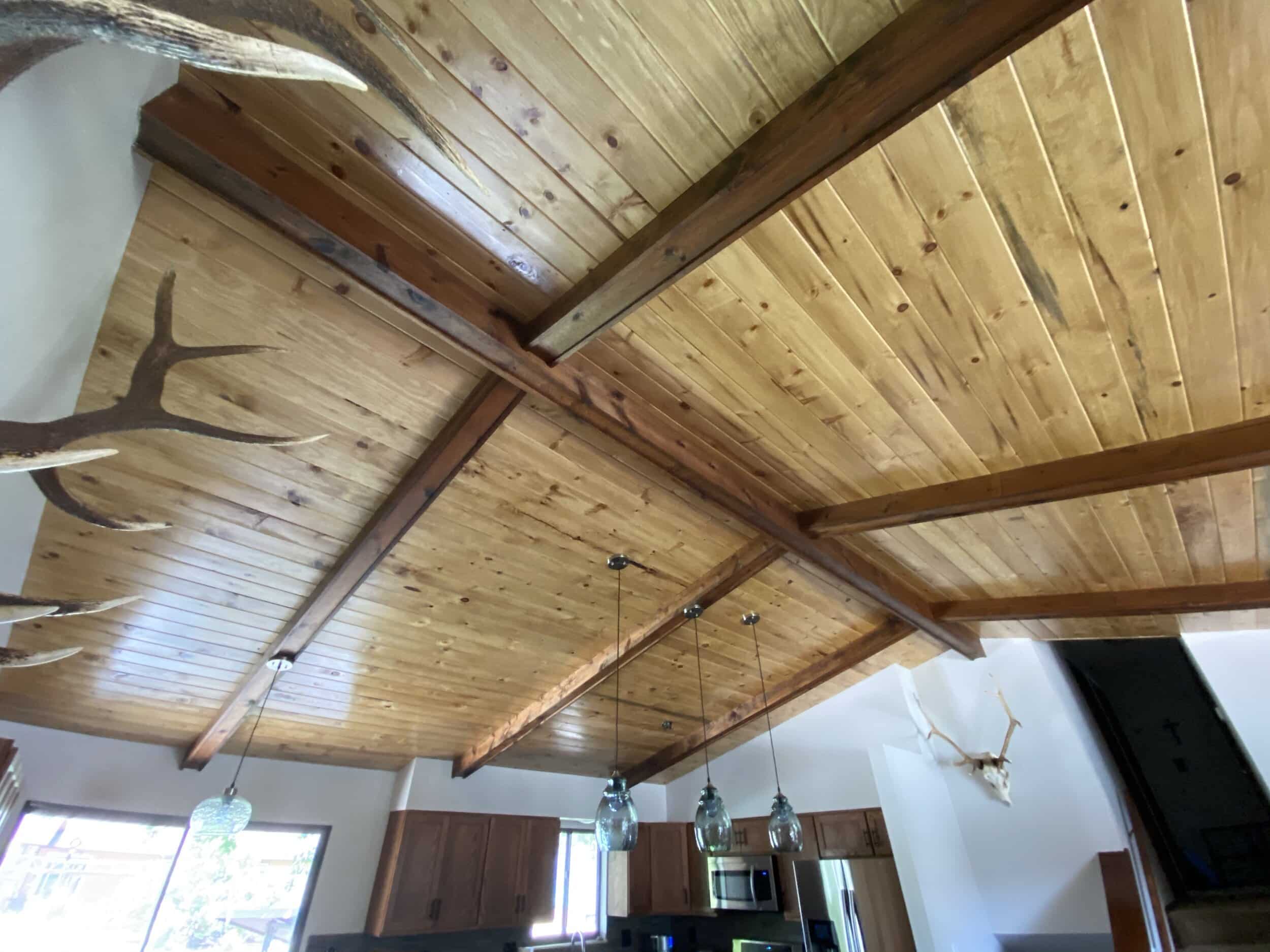 Vaulted wooden ceiling with support beams in farmhouse style home