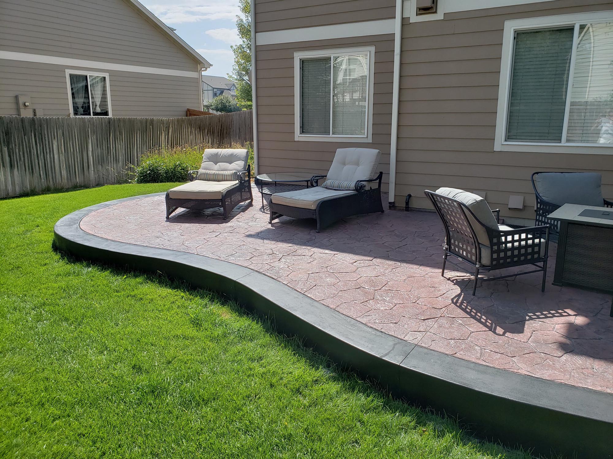 Curved stone patio with lounging chairs